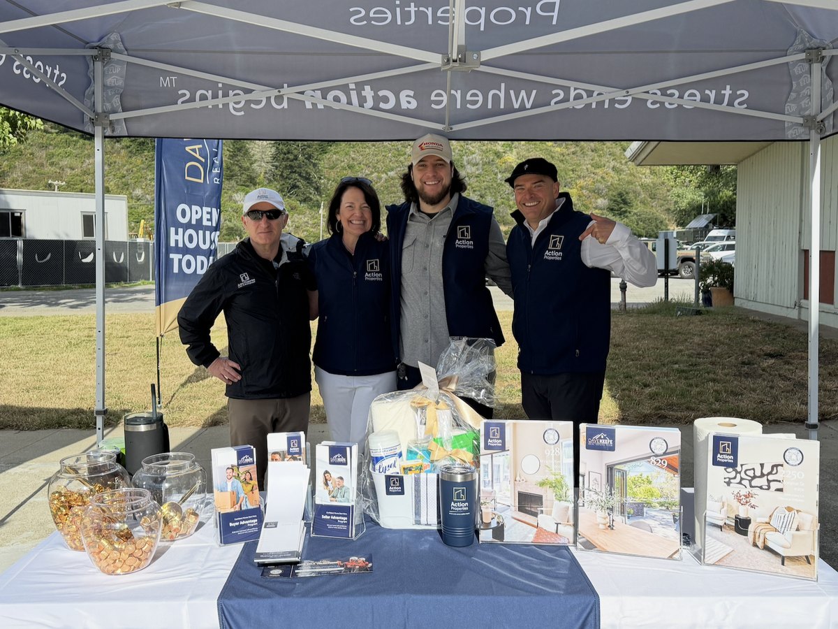 The Action Properties team at a branded open house tent with printed program materials