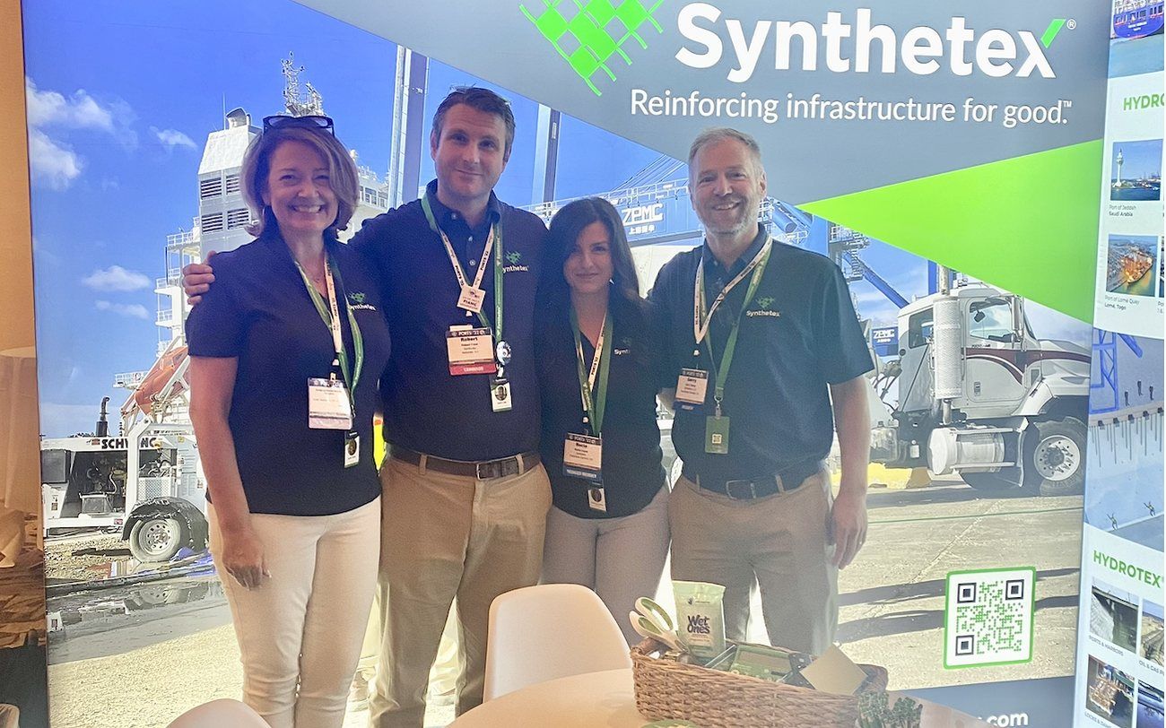 The Synthetex team at a port industry trade show, beneath the promise Reinforcing Infrastructure for Good